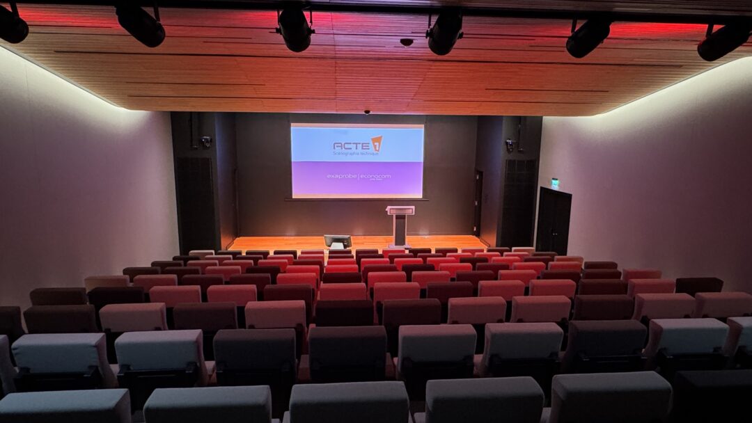 Auditorium avec sièges pour le public, vidéoprojection et un pupitre sur scène